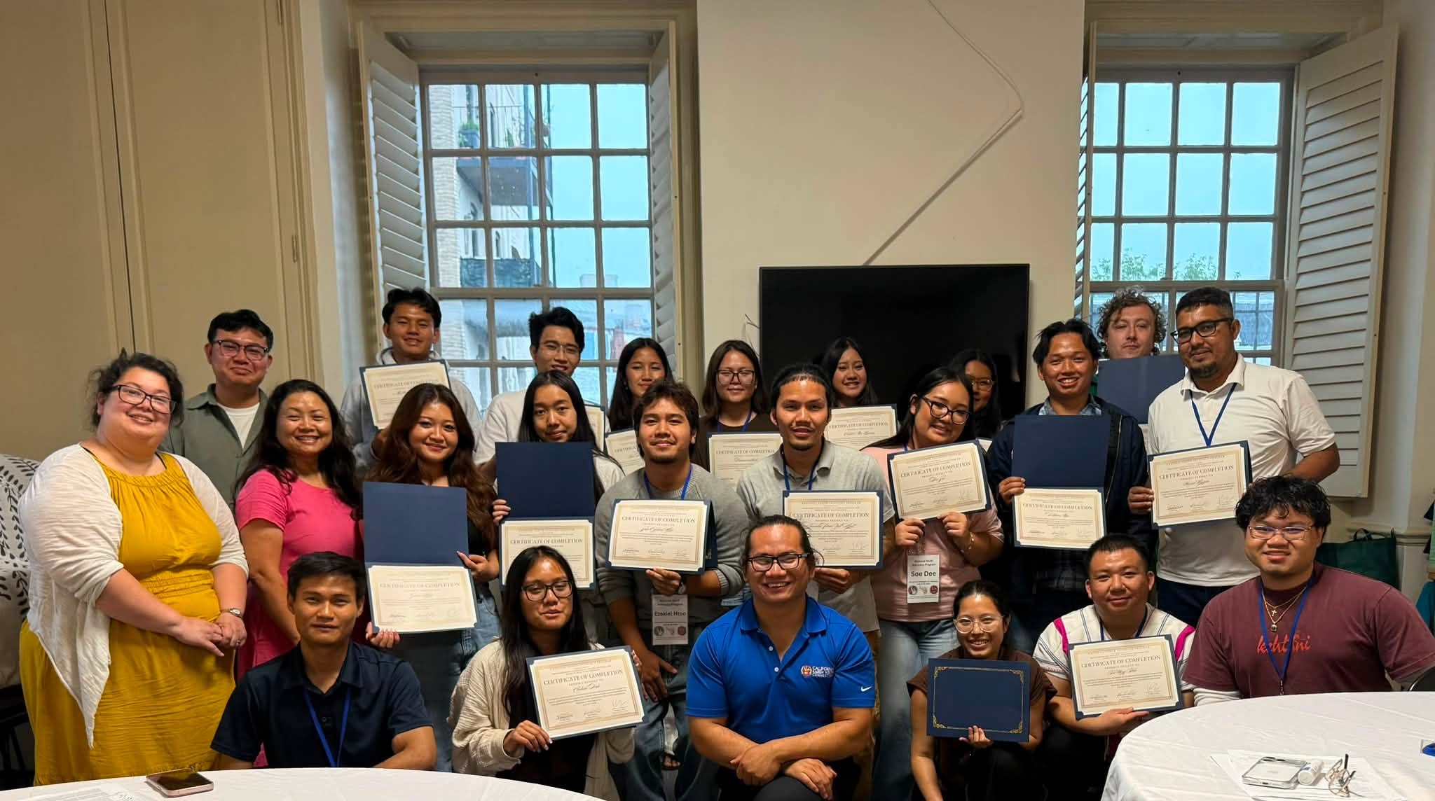 Participants holding certificates in a group photograph
