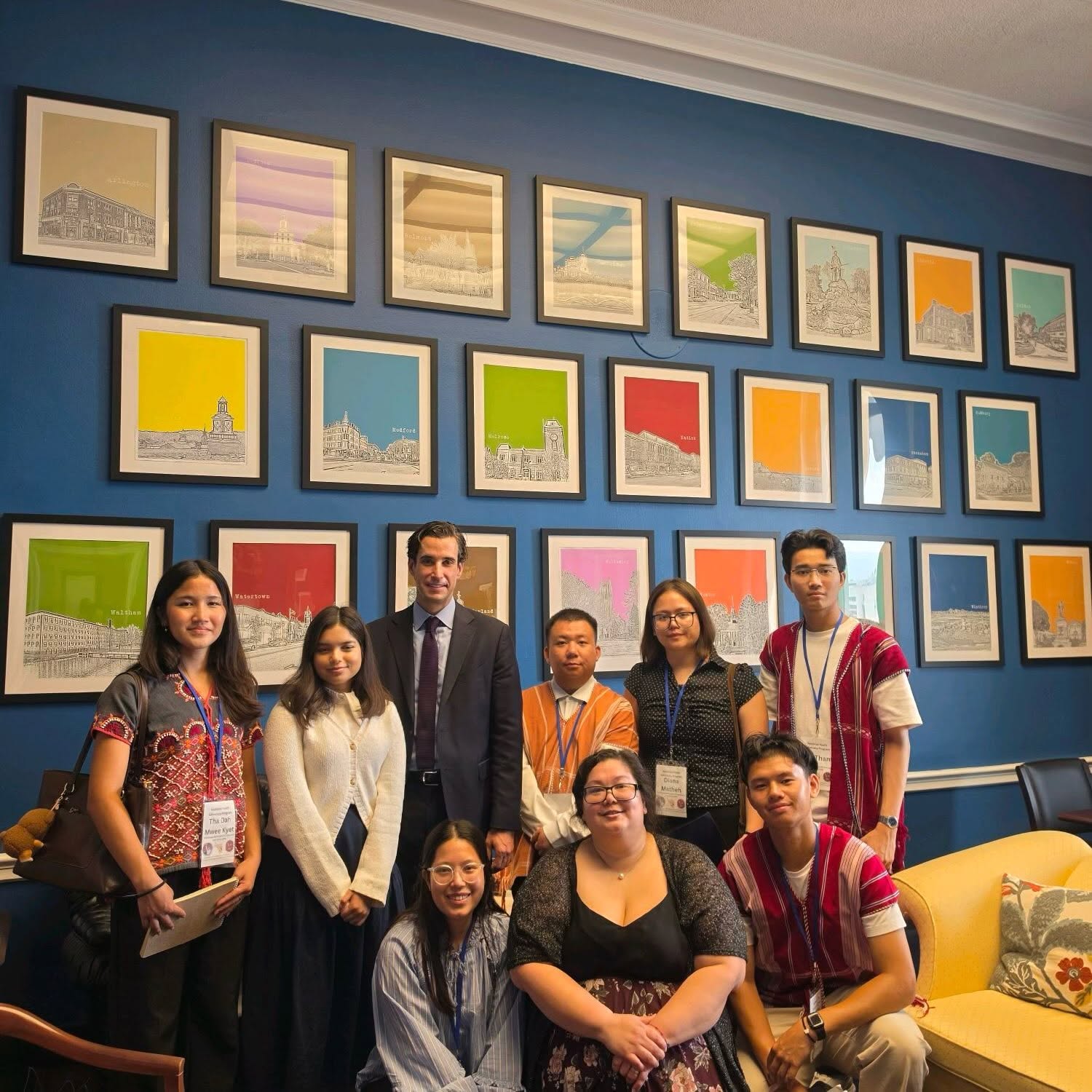 Group portrait in an office with framed city illustrations