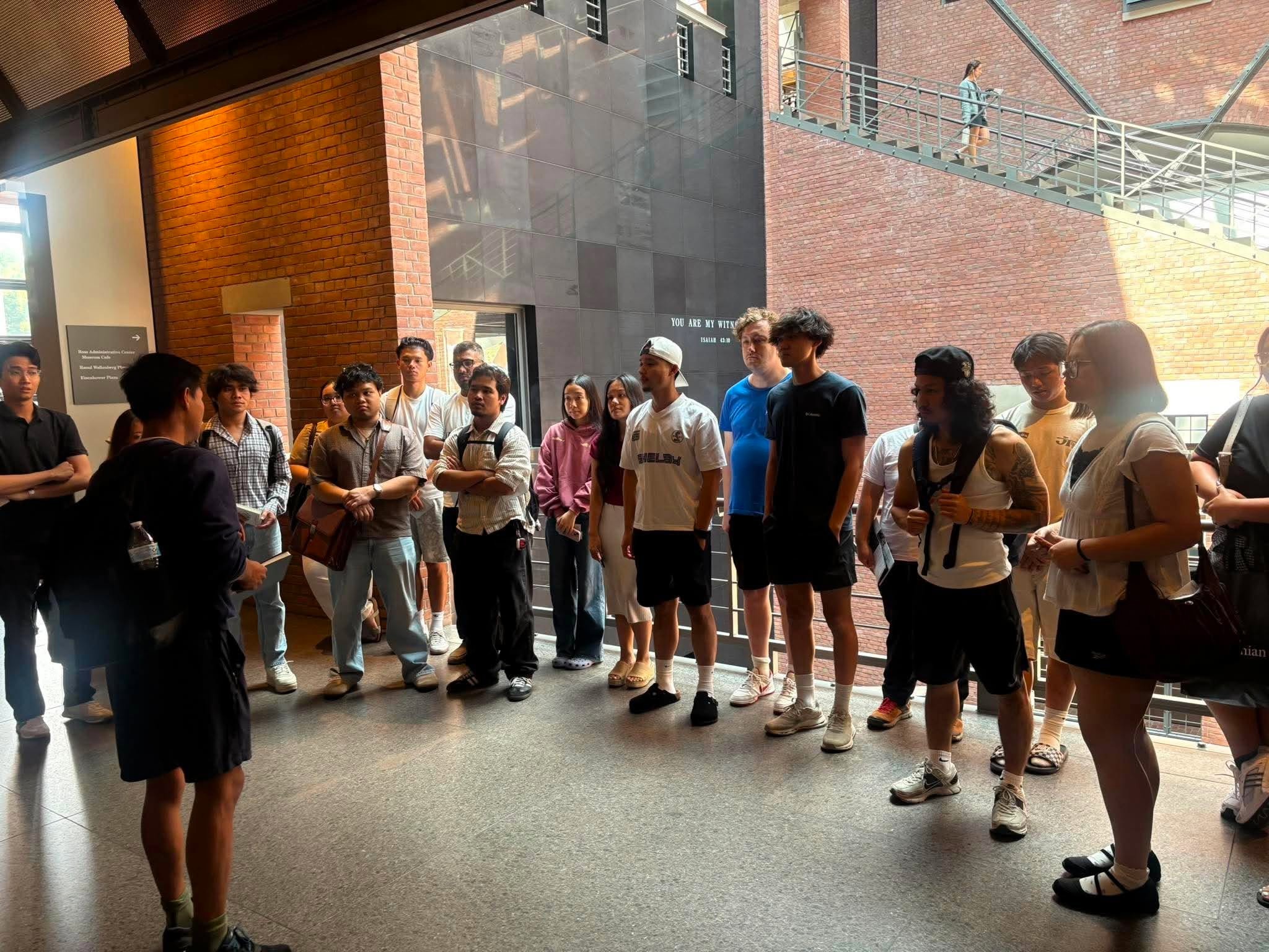 Participants listening to a speaker in a brick atrium