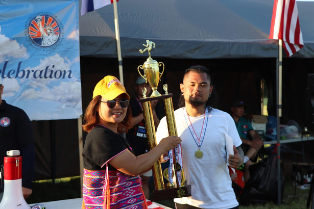 Karen community members holding an award at a sports gathering