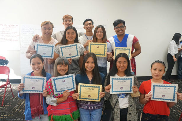 Young Karen community members holding certificates together